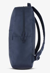 Granatowy plecak o prostokątnym kształcie, wykonany z wytrzymałego materiału, posiada zasuwany główny compartment i wyściełane szelki.