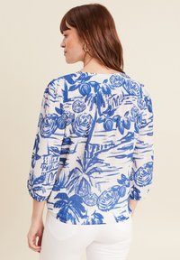 Damenbluse mit einem blau-weißen Blumenmuster, strukturiertem Stoff, 3/4-Ärmeln und einem runden Rückendesign.