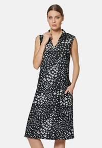 Schwarzes ärmelloses Kleid mit einem abstrakten Muster in Weiß und Hellblau, mit Kragen und Taschen auf beiden Seiten.