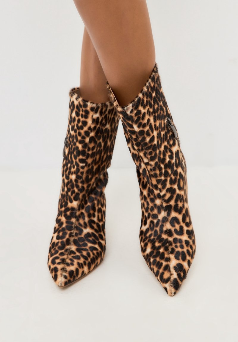 Leopard print ankle boots with pointed toes, made of soft fur-like material; feature a side zipper and a structured, fitted design.