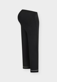 Pantalon de maternité noir avec une ceinture extensible prolongée et un bord blanc au niveau des jambes, vu de profil sur un fond clair.
