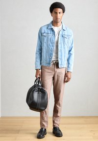 Veste en jean bleu clair, t-shirt blanc, pantalon en lin marron, sac en cuir noir, chaussures noires à enfiler, avec une texture lisse et un design décontracté.