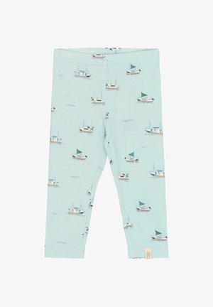 Leggings de color azul claro hechos de una tela suave, con un patrón náutico repetido de pequeños barcos con velas verdes y blancas.