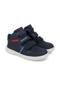 Zapatillas de alta en azul marino con correas de Velcro, suela blanca, tela transpirable y acentos en rojo y azul. Punta perforada para ventilación.