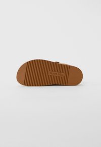 Sole of a brown sandal with ridged texture and centered "Steve Madden" logo on a plain white background.