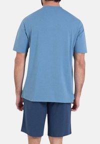 T-shirt à manches courtes, col rond, en bleu clair, fabriqué en tissu doux. Associé à un short bleu foncé, à la fois décontracté et confortable dans son design.