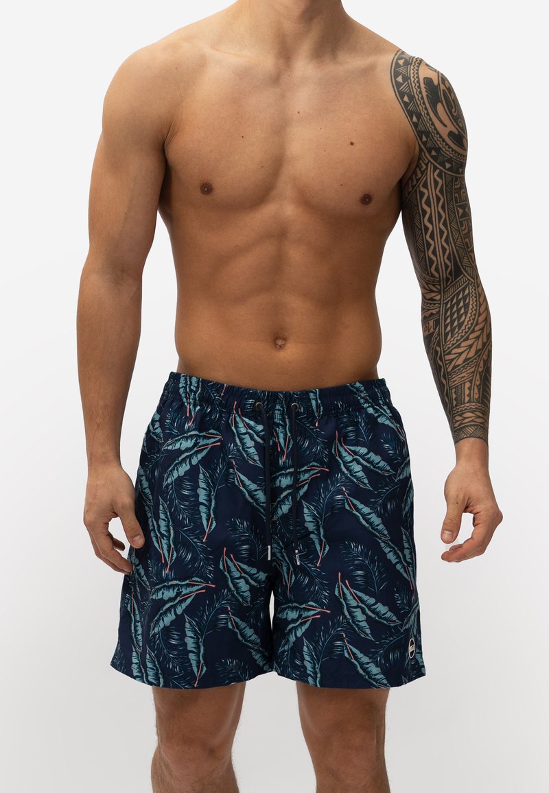 Marine zwemshorts met een tropisch bladerenpatroon in groen en rood. Gemaakt van lichtgewicht materiaal met een elastische tailleband en trekkoordsluiting.