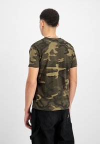 Sõjaväe roheline kamuflaažiga T-särk lühikeste varrukatega ja ümmarguse kaelusega, valmistatud pehmest puuvillast kangast, millel on peen tekstuur ja muster.