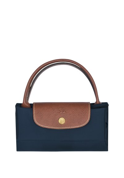 Marineblaue Nylon Tasche mit einem strukturierten, braunen Lederklappen und -griff. Verfügt über ein rundes Logo in goldfarbener Ausführung und einen Reißverschluss. Kompakte und strukturierte Form.