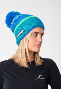 Blue and green knitted beanie with a fluffy pom-pom and horizontal stripes. Features a black reusch logo on the side.