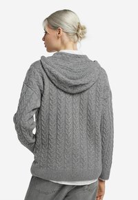 Szara dzianinowa bluza z kapturem z teksturowanym wzorem warkocza, ściągaczem u dołu i luźnym krojem, z kapturkiem na dole pleców.