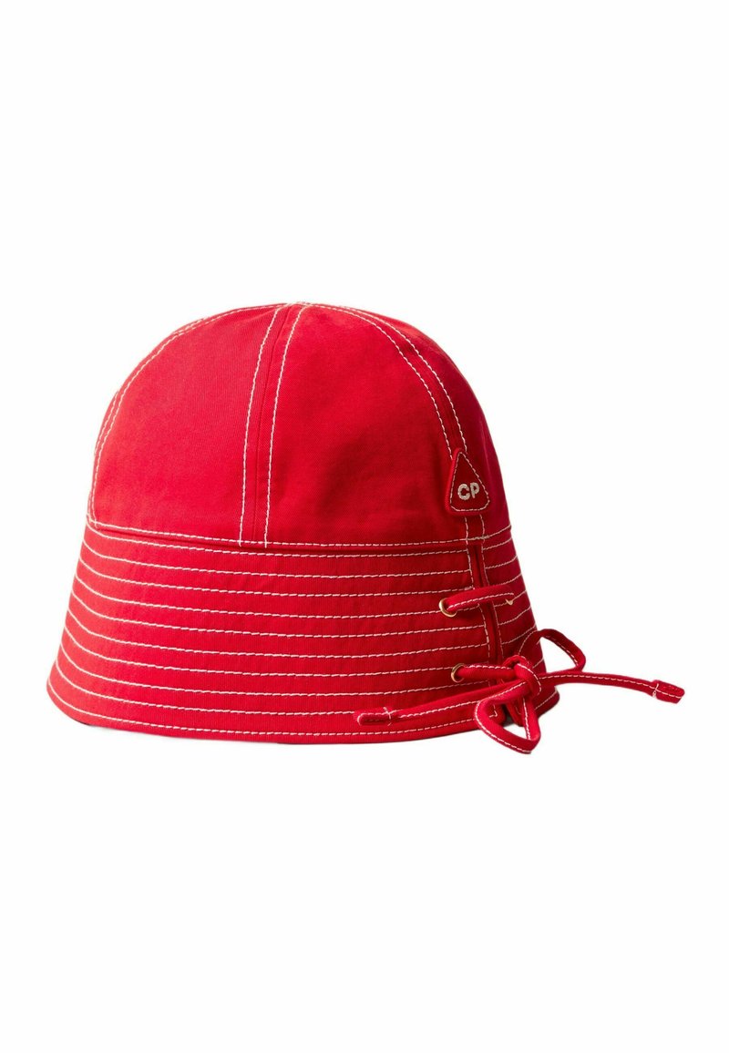 Cappello a secchiello rosso in canvas con cuciture bianche, dotato di una chiusura in pizzo laterale e un'etichetta con il logo "CP".