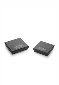 Due scatole regalo nere quadrate con una superficie liscia e una finitura opaca, con il testo "TRUE REBELS!" in grigio sulla parte superiore.