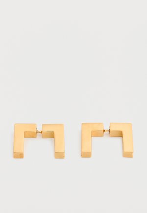 Uhani v obliki kvadrata iz kovine z zlatim odtenkom z moderno geometrijsko zasnovo, ki ležijo na belem ozadju.