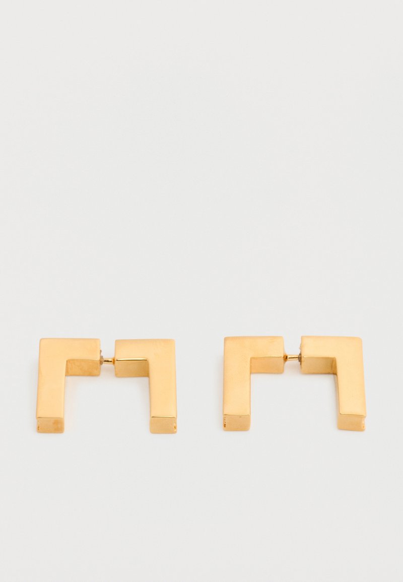 Σκουλαρίκια κρίκοι σε σχήμα τετράγωνου από μέταλλο με χρυσή απόχρωση και μοντέρνο γεωμετρικό σχέδιο, τοποθετημένα επίπεδα σε λευκό φόντο.