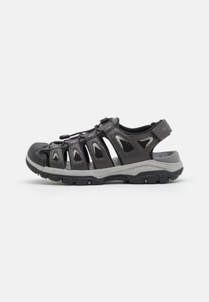 Geschlossene schwarze und graue Skechers Outdoor-Sandale mit verstellbaren Riemen und robustem Profil, entwickelt für Komfort und Langlebigkeit.