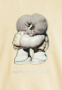 Sudadera crema con un gráfico bordado de dos figuras estilizadas abrazándose, con detalles texturizados en gris y blanco roto, contorneados en verde.