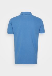 Pikétröja i enhetlig blå färg, kort ärm, krage och rak nederkant, tillverkad av textil med struktur. Inga mönster eller utsmyckningar syns.