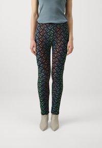 Leggings od rastezljivog materijala, s crnom pozadinom i višebojnim uzorkom povezane logotipa u zelenoj, narančastoj i plavoj boji.