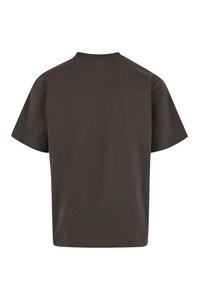 Tamsiai pilka medvilnė, trumpomis rankovėmis, su apykakle. Turi lygią nugarą, laisvą kirpimą ir glotnią tekstūrą. Be matomų logotipų ar raštų.