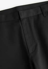 Zwarte op maat gemaakte broek met een soepele stof met een subtiele textuur, recht ontwerp en een gestikte tailleband.