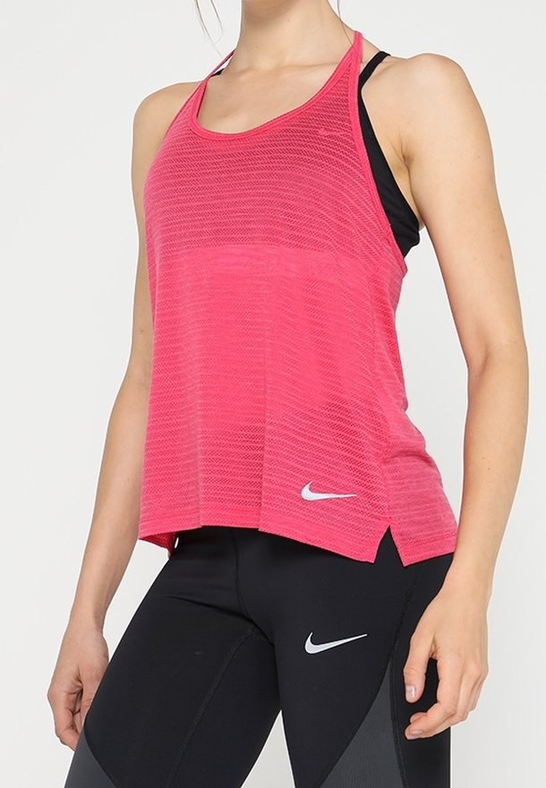 Różowy siatkowy top bez rękawów o sportowym fasonie, z okrągłym dekoltem i bocznymi rozcięciami, zestawiony z czarnymi legginsami z logo Nike.
