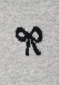 Motif en forme de nœud tricoté noir sur fond de tissu tricoté gris clair.