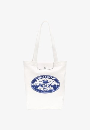 Weiße Tote-Bag aus Canvas mit langen Griffen, ausgestattet mit einem blauen Longchamp-Logo in der Mitte und einem Druckknopfverschluss oben.