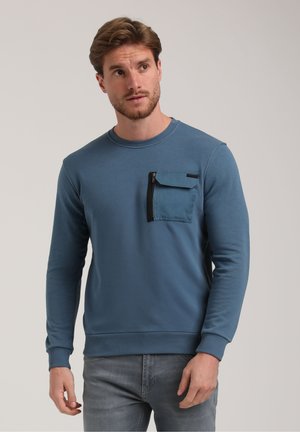 Felpa blu in cotone con maniche lunghe, polsini a costine, collo rotondo e tasca con zip sul lato sinistro del petto. Texture liscia.