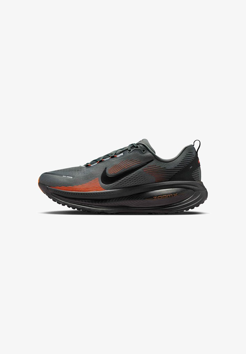 Scarpa da running Nike con una parte superiore in mesh grigia e dettagli rossi, un logo Nike swoosh nero e una suola testurizzata nera e grigia per un'ammortizzazione ottimale.