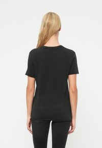 Μαύρο κοντομάνικο t-shirt από βαμβάκι· διαθέτει χαλαρή εφαρμογή, στρογγυλή λαιμόκοψη και ελαφριά υφή. Σχεδιασμένο με απλή, καθαρή πλάτη.