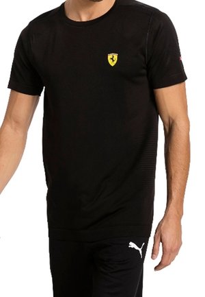 T-shirt nera a maniche corte realizzata in tessuto traspirante, con un piccolo logo giallo Ferrari sul petto. Tessuto liscio, vestibilità standard.