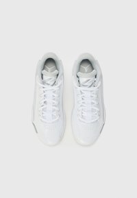 White athletic shoes with a smooth leather upper, mesh accents, flat laces, and prominent logo on the tongue. Rounded toe, cushioned collar.