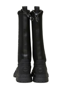Botas negras de alta hasta la rodilla con una parte superior suave y flexible, que presentan un panel con logotipo en relieve, tacón redondo y suela de goma texturizada. Cuerda ajustable en la parte superior.