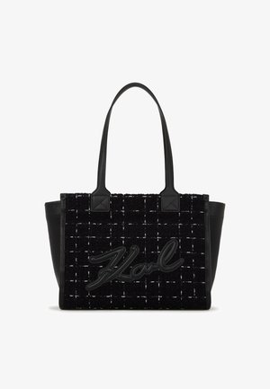 Czarna torba na ramię z teksturowanym materiałem w ciele oraz plecionym wzorem, gładkimi czarnymi skórzanymi akcentami i wyraźnym wytłoczonym logo.