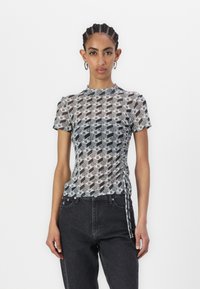 Mesh short-sleeve top featuring a black and white geometric pattern, round neckline, and adjustable side ruching for a fitted look.