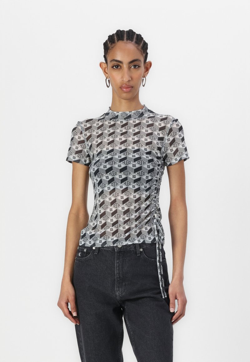 Mesh short-sleeve top featuring a black and white geometric pattern, round neckline, and adjustable side ruching for a fitted look.