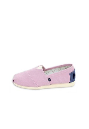Zapato casual tipo slip-on con parte superior de tela color lila claro, suela blanca y parche azul oscuro en el talón, visto de lado sobre fondo blanco.