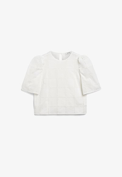 Hvit bomullsskjorte med puffermene, med et rutemønster og små broderte detaljer. Åpning med nøkkelhull bak i halsen.