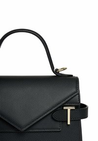 Borsa nera con texture e forma strutturata, con accenti in metallo dorato e una patta piegata. Manico liscio per il trasporto.