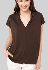 Haut marron à manches courtes avec décolleté en V et détails plissés. Fabriqué en tissu lisse, il présente une coupe décontractée et des poches latérales.