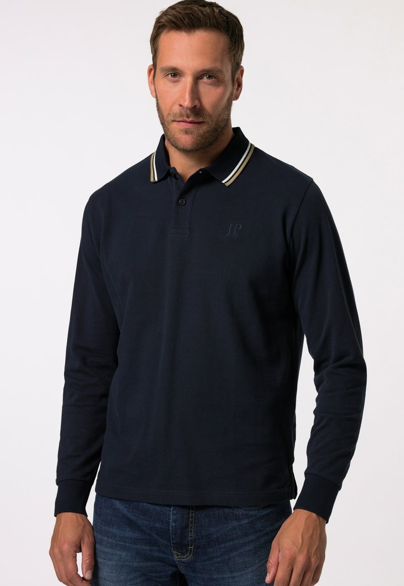 Marineblaues Langarm-Polohemd mit einer Zwei-Knopf-Leiste, das über einen gerippten Kragen mit weißen und gelben Streifen sowie ein eingestanztes Logo verfügt.