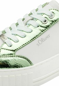 Adidași albi cu accente strălucitoare verzi, închidere cu șireturi, suprafață texturată și o talpă groasă, cu nervuri, albă. Include branding s.Oliver.