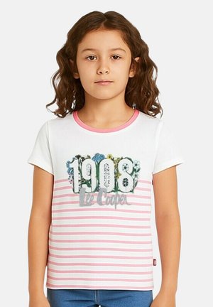 Fille aux cheveux bouclés bruns portant un T-shirt à rayures blanches et roses avec l'inscription "1908 Lee Cooper" et un motif floral à l'avant.