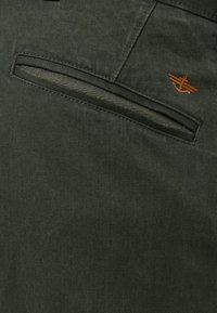 Spodnie khaki z ukośną kieszenią zapinaną na zamek, wykonane z wytrzymałego materiału, z pomarańczowym haftowanym kotwiczkiem.