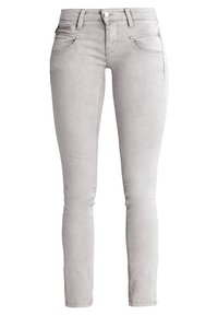 Jean skinny en denim gris avec une texture lisse, cinq poches et une braguette zippée. Présente des surpiqûres discrètes et un design élégant et ajusté.