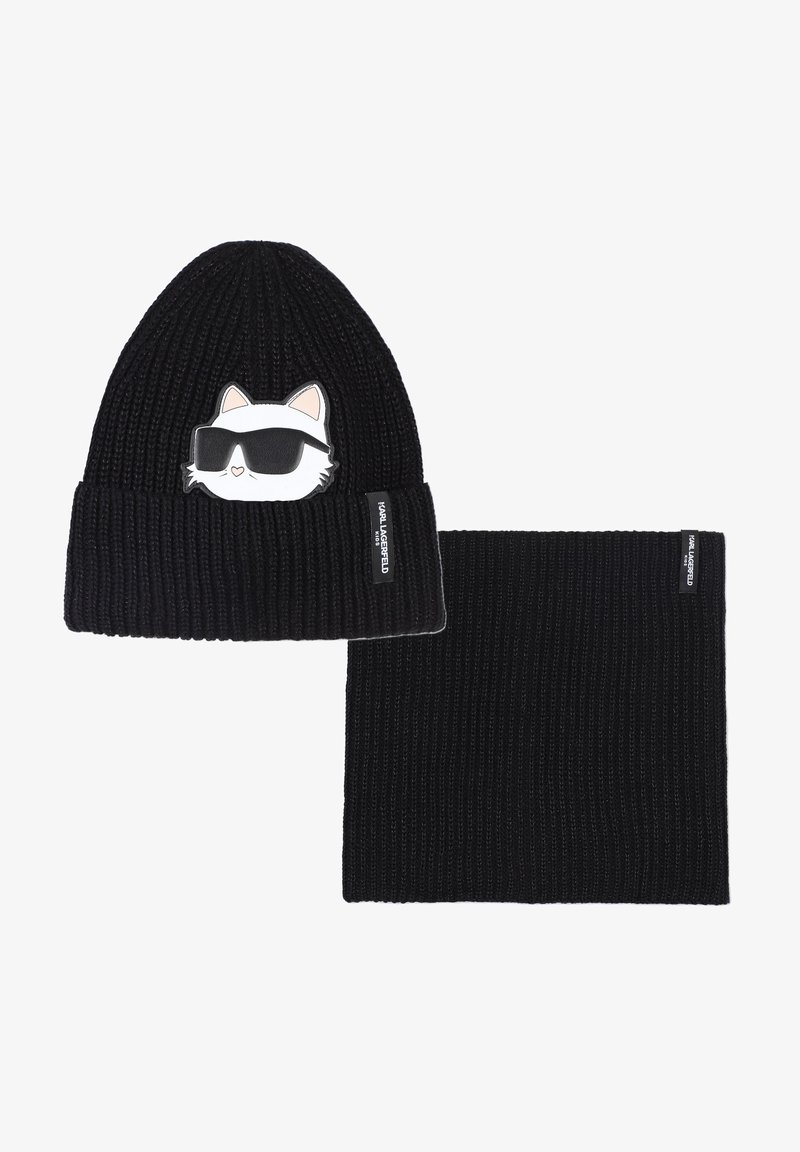 Melna adīta cepure un atbilstoša šalle. Cepure rotāta ar kaķa grafiku saulesbrillēs. Abiem ir ribota tekstūra un zīmola etiķetes.