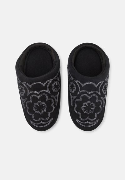 Zwarte slippers met een geborduurde bloemenontwerp in zilverdraad. Zachte stoffen voering met een ronde neus en gevoerde randen voor comfort.