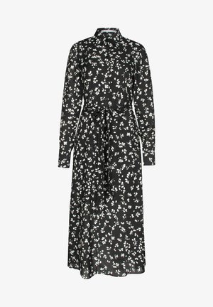 Robe chemise noire en midi avec un motif de feuilles blanches, manches longues, fermeture à boutons sur le devant, col et ceinture en tissu assorti nouée à la taille.