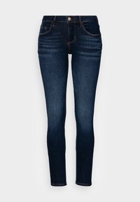 Jeans in denim di un blu scuro con una vestibilità slim. Presentano cinque tasche, una chiusura con bottone e dettagli in cucitura arancione. Texture liscia.